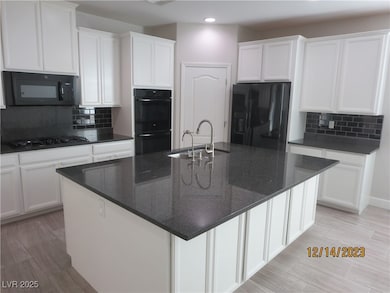 Kitchen featuring white cabinetry, black appliance