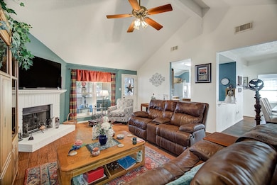 Living Room (Angle 3) – Cozy seating arrangement highlighted by the central fireplace and backyard views through the adjacent windows.