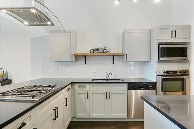 Kitchen with appliances with stainless steel finishes, a sink, extractor fan, decorative backsplash, and open shelves