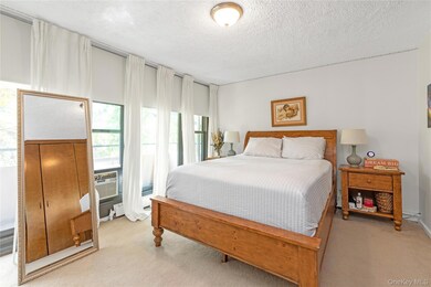 Bedroom featuring light carpet and a textured ceiling