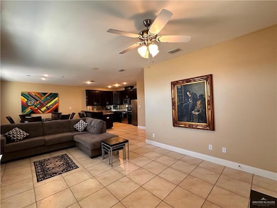 Living area with light tile patterned floors, a ceiling fan, and recessed lighting