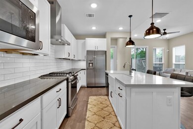 The kitchen features quartz countertops, shaker st