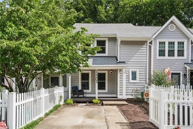 Multi unit property featuring covered porch and a shingled roof