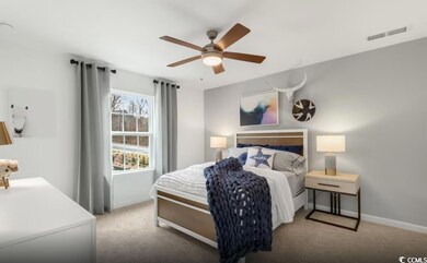 Carpeted bedroom featuring baseboards and a ceiling fan