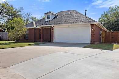 View of front of house with brick siding, driveway, roof with shingles, and an attached garage