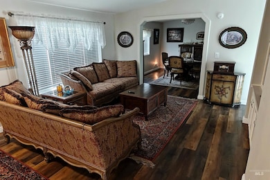 Living area featuring arched walkways and dark wood-style flooring