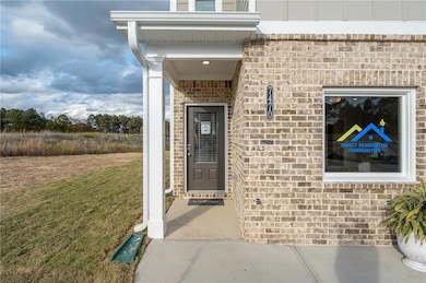 Entrance to property with brick siding and a lawn
