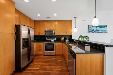 Entertainers kitchen  featuring granite countertops, stainless steel appliances, and tons of cabinets for storage. An open breakfast bar flows seamlessly into the living area, perfect for entertaining.