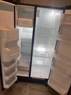 Kitchen view of refrigerator, dark wood-type flooring, and a barn door