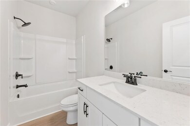 Bathroom featuring shower / washtub combination, vanity, and light wood finished floors