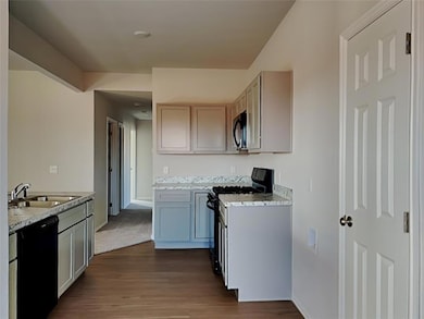 Kitchen with black appliances, a sink, dark wood f