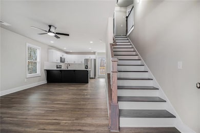 Staircase with wood-type flooring, ceiling fan, an