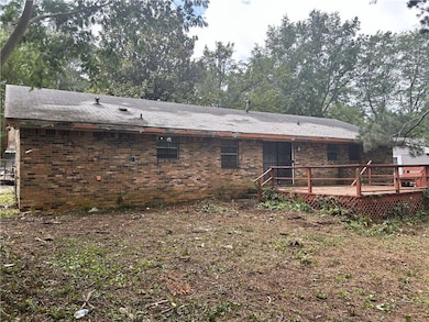 Rear view of house with a wooden deck and brick siding