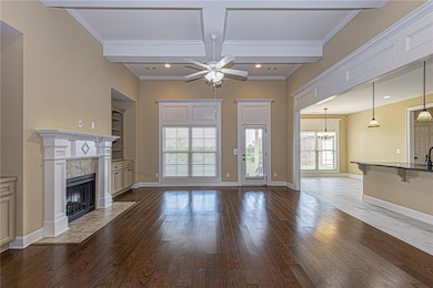 Unfurnished living room featuring recessed lighting, hardwood / wood-style flooring, ornamental molding, coffered ceiling, and a fireplace