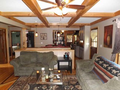 Custom handcrafted wood beams on the ceiling in the living room draw your eye up in admiration and flow easily into the kitchen just past the breakfast bar.
