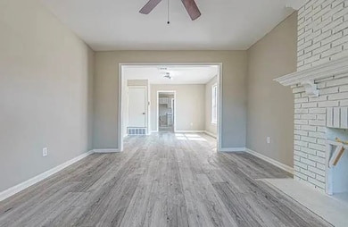 Unfurnished living room featuring ceiling fan and wood finished floors