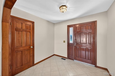 Entrance foyer featuring baseboards and light tile patterned floors