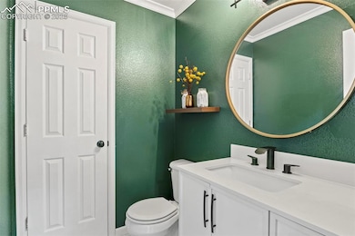 Half bathroom featuring a textured wall and vanity