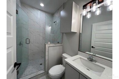 Bathroom with a marble finish shower, toilet, vanity, recessed lighting, and marble finish floors