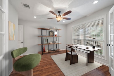 Bright study with large window, wood-look floors, and French door entry. Ideal for a home office, guest space, or easy second-bedroom conversion.