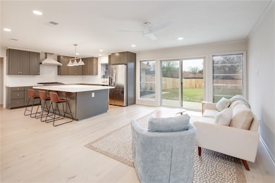 Living area with light wood finished floors, crown
