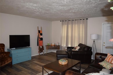 Living area featuring wood finished floors and a textured ceiling