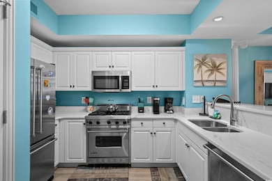 Kitchen featuring high end appliances, a sink, whi