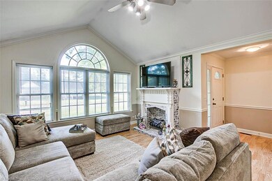 The living room features a plethora of natural lighting from the wall of windows.