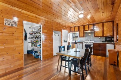 Dining room featuring light wood-style flooring, wood walls, and wood ceiling