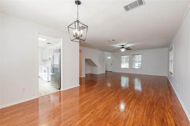 Unfurnished living room featuring a chandelier, l