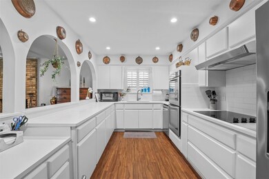Kitchen featuring wall chimney exhaust hood, sink,