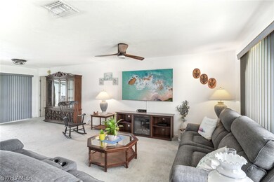 Carpeted living room with ceiling fan