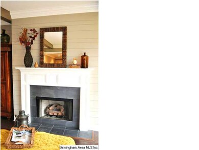 The fireplace has a painted tongue and groove wall