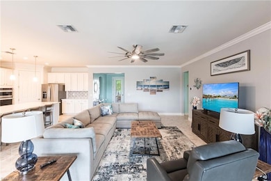 Living area featuring a ceiling fan, baseboards, v