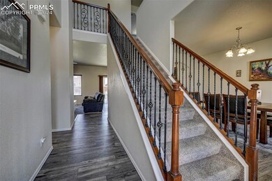 Staircase with a chandelier, dark wood-type floori