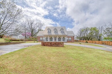 Cape cod-style house with curved driveway, fence, 
