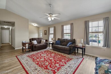 Living room featuring a ceiling fan, light wood lo