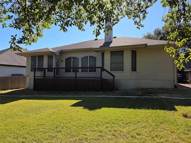 Back of house featuring a chimney, a wooden deck,