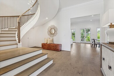 This stylish entryway showcases a sweeping stairca