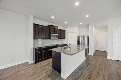 Large kitchen with granite counters and stainless appliances.