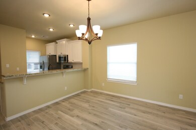 Dining area and breakfast bar, plenty of lighting here and throughout the home.
