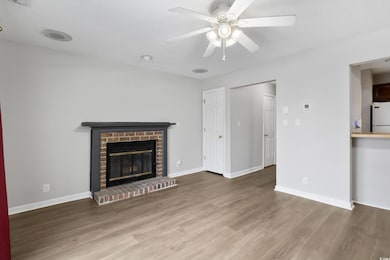 Unfurnished living room with ceiling fan, a firepl