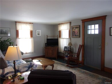 Living room, natural wood trim, wood plank floors.