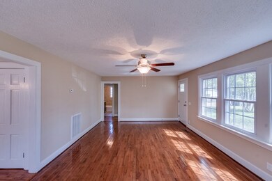 Spacious Living Room/Family Rm with Ceiling Fan.  Hardwood floors were just refinished, new windows, ceiling fan and whole room freshly painted!  Open to the Dining Room off the kitchen. 