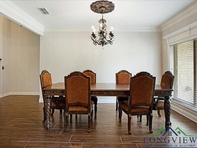 Dining area with a chandelier, dark wood finished floors, and ornamental molding