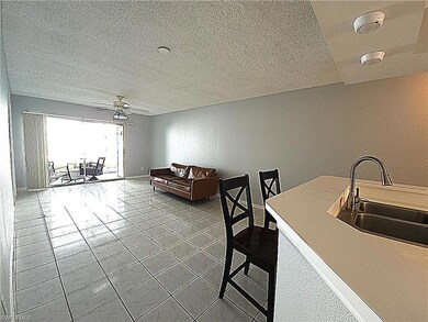 Tiled dining space featuring vaulted ceiling, a te