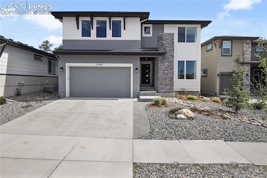 View of front facade with stucco siding, concrete driveway, and an attached garage
