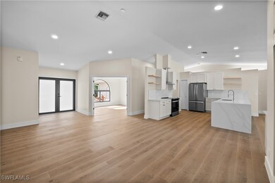 Kitchen featuring white cabinetry, sink, light har