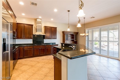 Kitchen featuring wall chimney range hood, a sink,