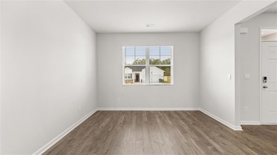 Unfurnished room with dark wood finished floors and baseboards